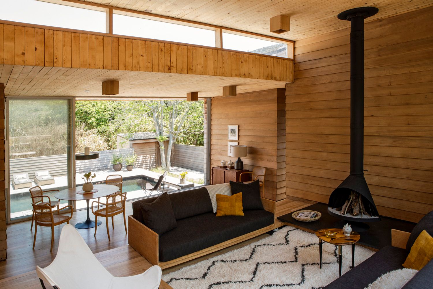 Image may contain Indoors Interior Design Lamp Wood Plant Chair Furniture Couch Home Decor Rug and Architecture