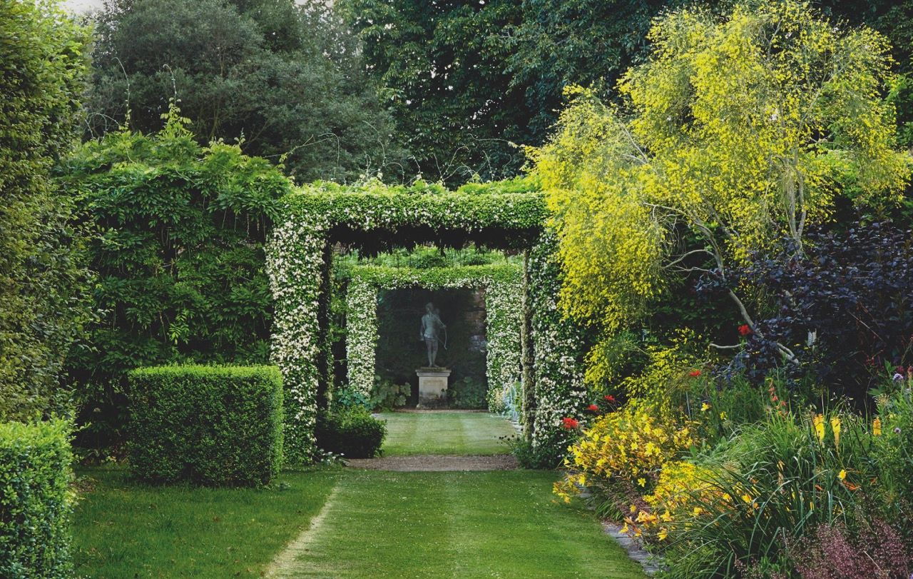 Image may contain Garden Nature Outdoors Grass Plant Arbour Person Park Fence Hedge Backyard and Yard