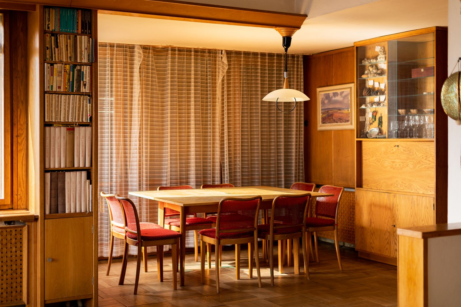 The dining room is tidy fitted with built in wooden shelves