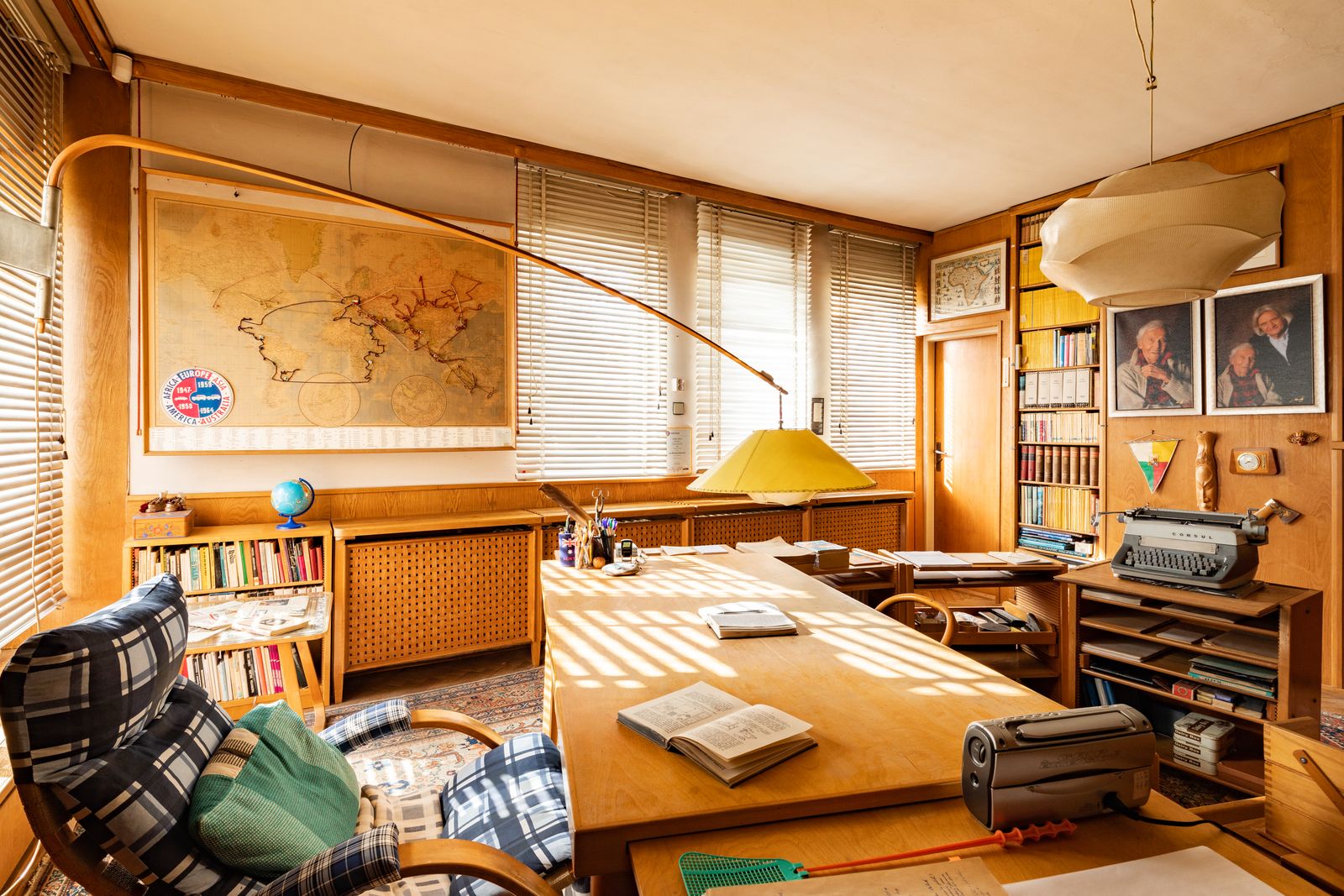 A light with yellow shade dramatically cantilevers over the desk in Miroslav Zikmunds study